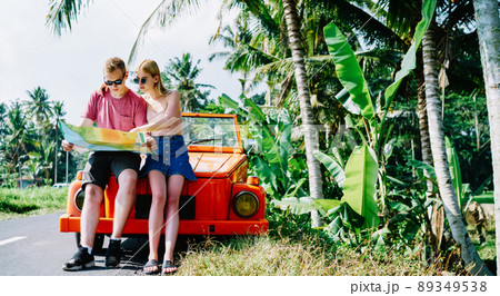 Couple exploring map while traveling by car 89349538