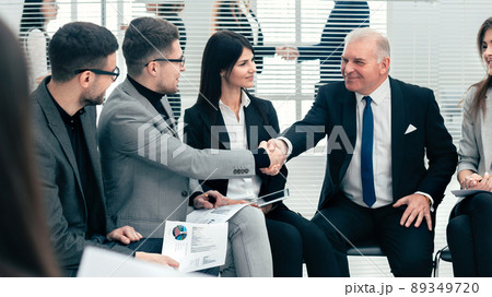 businessman and businesswoman shaking hands in a conference room businessman and businesswoman shaking hands in a conference room 89349720
