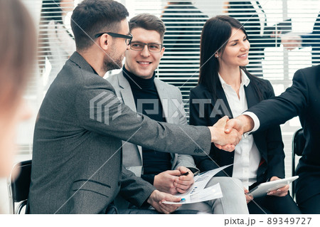 boss shaking hands with an employee during a work meeting boss shaking hands with an employee during a work meeting 89349727