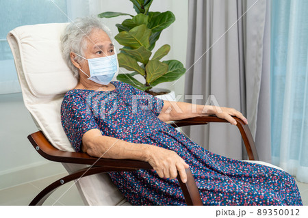 Asian elderly woman sitting and relaxing with happy in rocking chair at room in home. 89350012