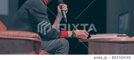 close up.speaker sitting in a chair and making a report during a business meeting close up.speaker sitting in a chair and making a report during a business meeting 89350430