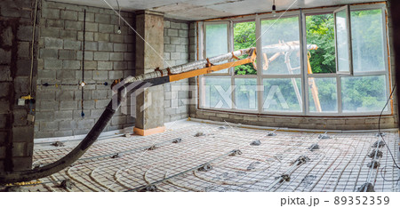 Concrete pump pours concrete into the house to level the floor in the apartment 89352359