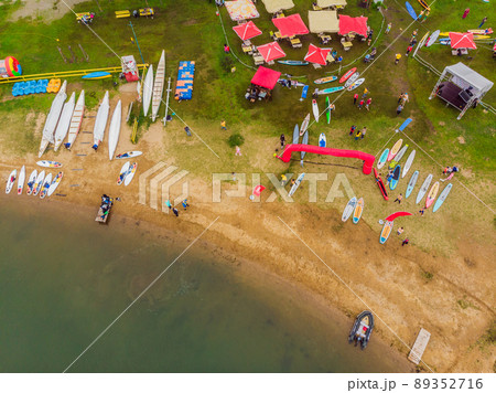 Strong men floating on a SUP boards in a beautiful bay on a sunny day. Aerial view of the men crosses the bay using the paddleboard. Water sports, competitions Strong men floating on a SUP boards in a beautiful bay on a sunny day. Aerial view of the men crosses the bay using the paddleboard. Water sports, competitions 89352716