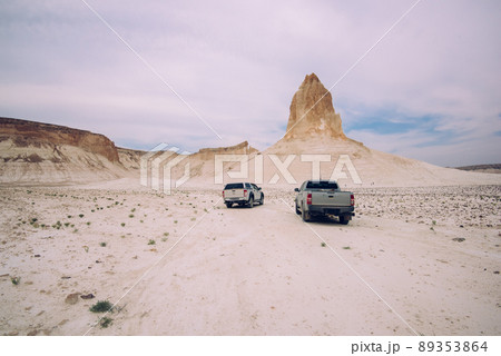 Cars driving along sandy desert area Cars driving along sandy desert area 89353864