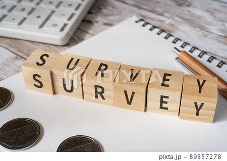 調査のイメージ｜「SURVEY」と書かれた積み木、電卓、コイン、ノート、ペン 89357278