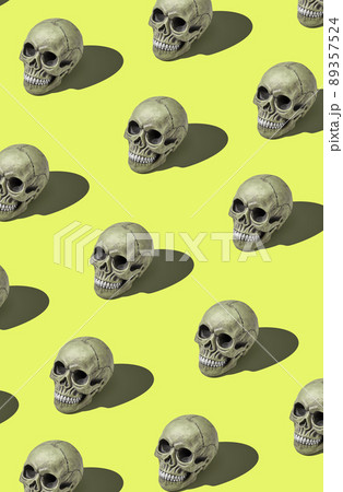 A lot of realistic models of a human skulls with teeth on a yellow background. Medical science or Halloween horror concept. A lot of realistic models of a human skulls with teeth on a yellow background. Medical science or Halloween horror concept. 89357524