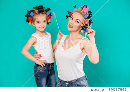 Funny family Mother and her child daughter girl with a paper accessories. Funny family Mother and her child daughter girl with a paper accessories. 89357941