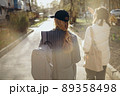 Back view portrait of two women walking and talking in a park asunny day 89358498