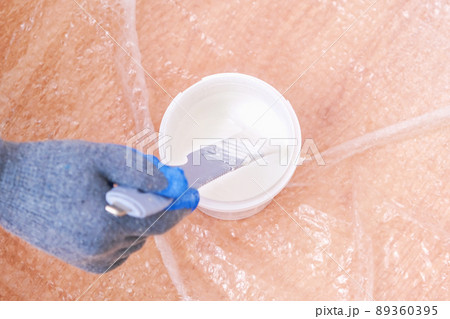 A man stirs white acrylic paint with special A man stirs white acrylic paint with special 89360395