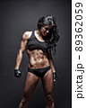 Female fitness model posing on black background 89362059