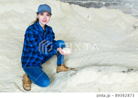 Woman farmer checking quality of maize flour Woman farmer checking quality of maize flour 89362873