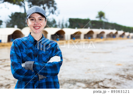 Smiling female farmer posing at dairy farm Smiling female farmer posing at dairy farm 89363121
