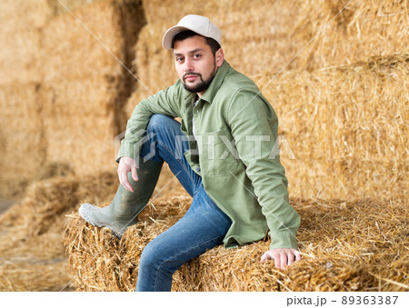 Man posing at straw storage on farm Man posing at straw storage on farm 89363387