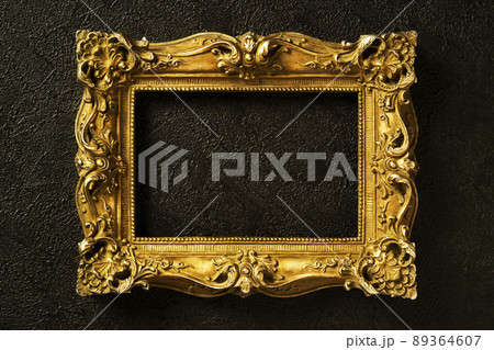 黒い壁に掛けられた金色のアンティークな額縁の写真素材 [89364607