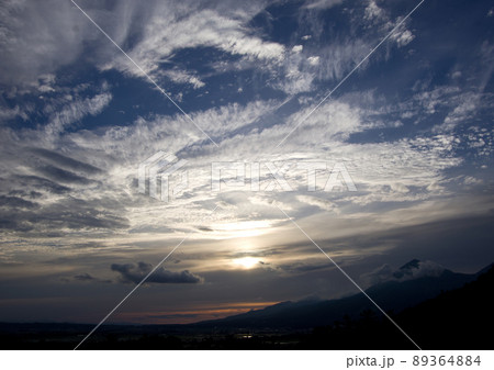 磐梯山の上空に夕日で輝く雄大な雲が広がり、青空とのコントラストが綺麗だ。 89364884