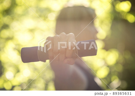 Side view of a woman exercising wth dumbbells in nature 89365631