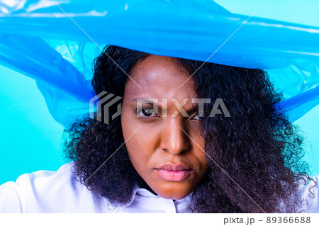 unhappy female with plastic bag on her head against blue wall studio unhappy female with plastic bag on her head against blue wall studio 89366688