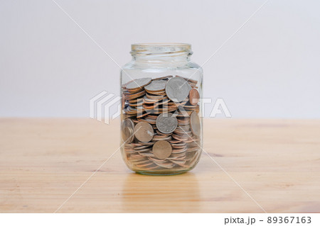 Glass jars with coins on wooden desk. Savings and Investments concept. 89367163