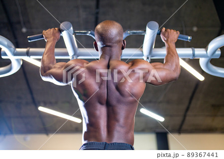 mulatto coach lifting weights over dark background in new gym 89367441
