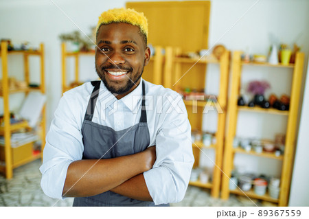 mixed race man making a vase in pottery studio 89367559