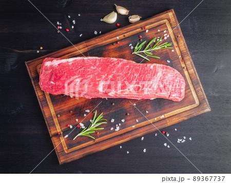 Raw meat, beef steak with seasoning on chopping board on dark background with rosemary, Raw meat, beef steak with seasoning on chopping board on dark background with rosemary, 89367737