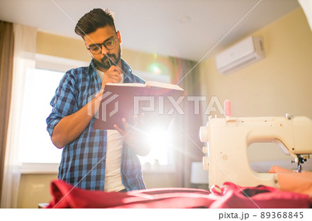 indian man sewing new collection in showroom in living room 89368845