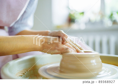 Potter hands sculpts a vase from clay on a Potter close up Potter hands sculpts a vase from clay on a Potter close up 89368927