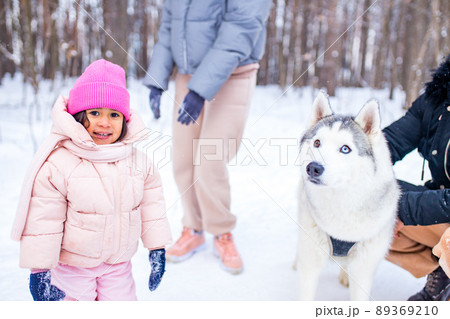 mixed race family in threesome spending new year holidays in park with their husky dog 89369210