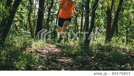 Woman runner running on forest trail Woman runner running on forest trail 89370855