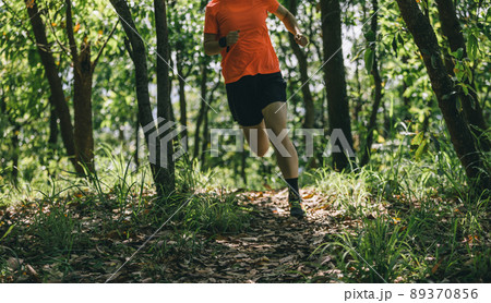 Woman runner running on forest trail Woman runner running on forest trail 89370856