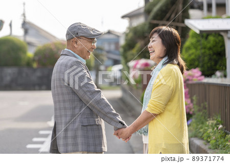 手を繋いで笑顔で見つめ合うシニア夫婦 手を繋いで笑顔で見つめ合うシニア夫婦 89371774