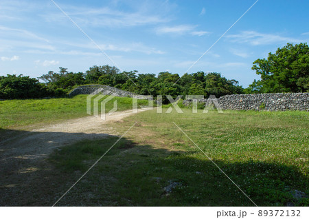 森へ続く石垣と木々の間にある未舗装路 89372132