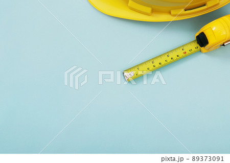 yellow tape measure background in the project at construction site building on concrete floor on city with sunlight. tool for workman as engineer or worker. 89373091