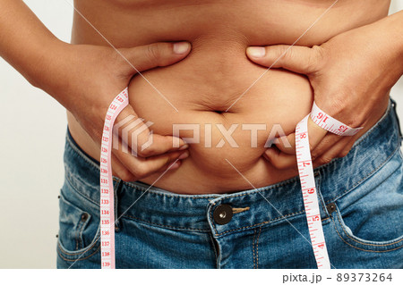 fat man check out body overweight abdomen his belly with in hand measuring tape fat man check out body overweight abdomen his belly with in hand measuring tape 89373264
