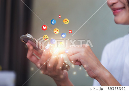 Young woman using smartphone sending emojis. Mobile smartphone sending text messages emoji emoticon. Young woman using smartphone sending emojis. Mobile smartphone sending text messages emoji emoticon. 89373342