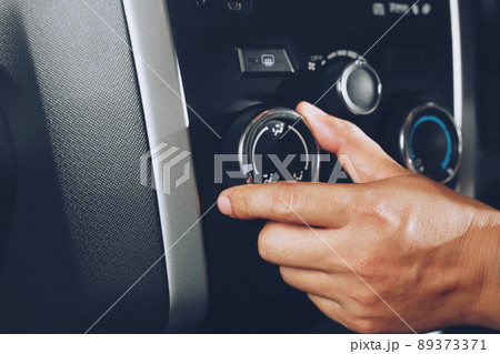 Closeup of hand driver man checking switch adjusting air from conditioning the cooling system with flow of cold in car. Leave space for writing text. 89373371