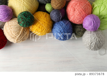 Balls of yarn on white wooden background 89373678