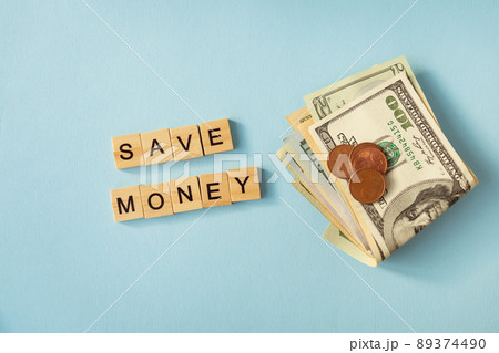 Money in international currency, dollars, euro coins lie on a blue background. Lettering save money. 89374490
