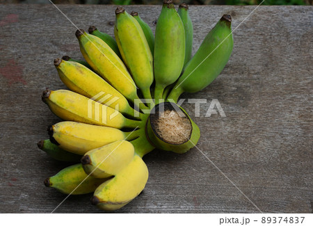 Ripe banana fruit green and yellow color from organic farm with nature light, put on wooden table background Ripe banana fruit green and yellow color from organic farm with nature light, put on wooden table background 89374837