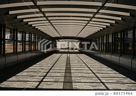 抽象画　光と影が織りなす模様　長いビル間連絡橋の左右対称画 89375464