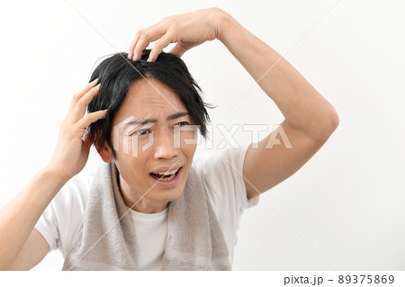 頭を抱えるアジア人男性 89375869