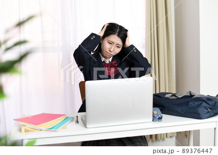 パソコンの前で悩む女子学生 89376447