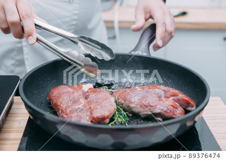 Cooking beef ribeye steak in a frying pan in the cooking class. Steak with spices. Cooking process, close-up. Cooking beef ribeye steak in a frying pan in the cooking class. Steak with spices. Cooking process, close-up. 89376474