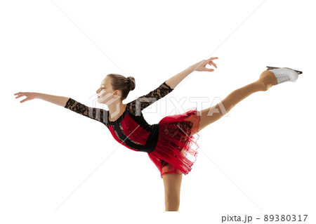 Portrait of little flexible girl, figure skating wearing stage attire posing isolated on white studio backgound. Concept of movement, sport, beauty. Portrait of little flexible girl, figure skating wearing stage attire posing isolated on white studio backgound. Concept of movement, sport, beauty. 89380317
