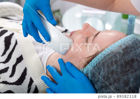Young woman receiving electric galvanic anti-aging face spa massage at beauty salon. Young woman receiving electric galvanic anti-aging face spa massage at beauty salon. 89382118