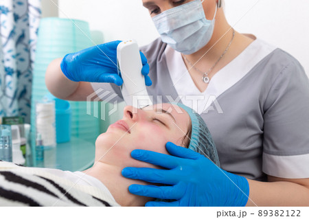 Young woman receiving electric galvanic anti-aging face spa massage at beauty salon. Young woman receiving electric galvanic anti-aging face spa massage at beauty salon. 89382122
