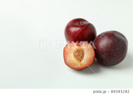 Plums with a half on a white background Plums with a half on a white background 89383282