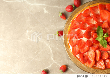 Wooden stand with strawberry tart on gray textured background 89384249