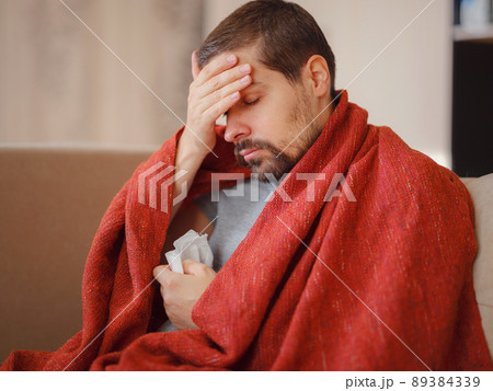 Sick man of corona virus lying down in sofa recovery from illness in home. Sick man of corona virus lying down in sofa recovery from illness in home. 89384339