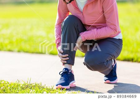 運動中に痛めたふくらはぎを押さえるミドル女性 89384669